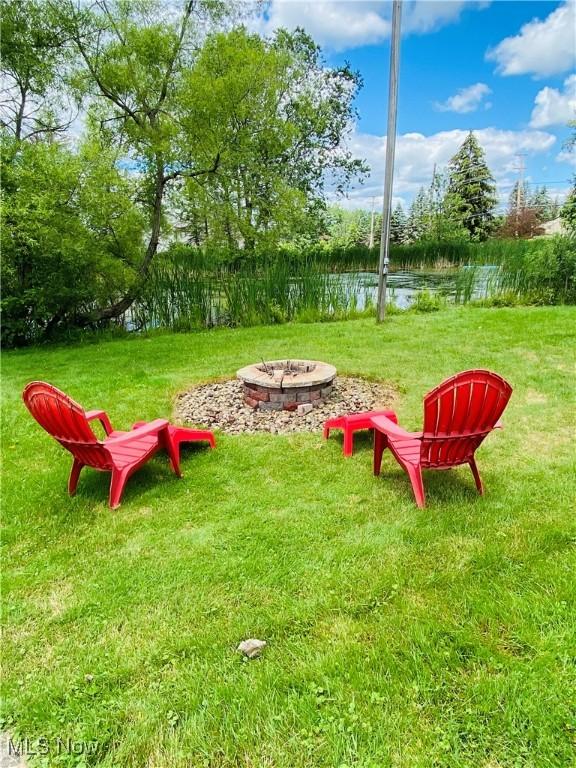 view of yard with a water view and an outdoor fire pit