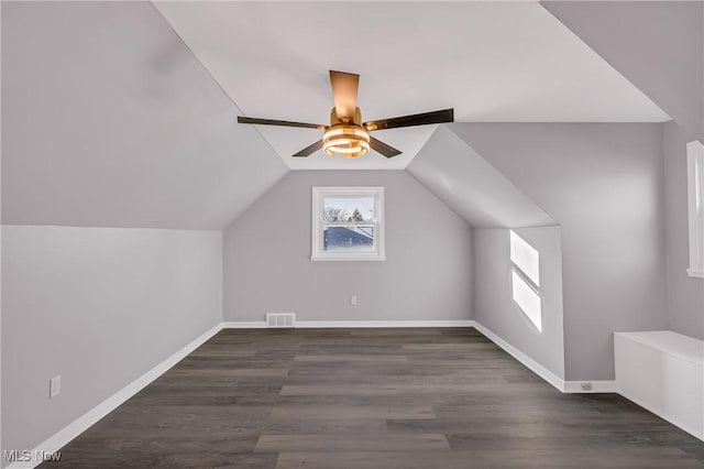 additional living space featuring dark hardwood / wood-style flooring, vaulted ceiling, and ceiling fan