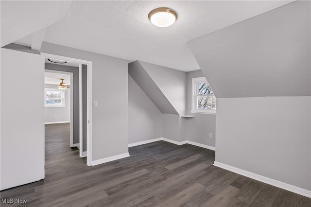 bonus room with ceiling fan, dark wood-type flooring, and vaulted ceiling