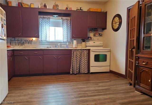 kitchen with sink, white appliances, and light hardwood / wood-style floors