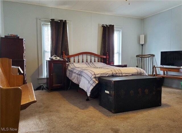 carpeted bedroom with ornamental molding