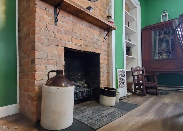 living room featuring built in shelves and hardwood / wood-style flooring