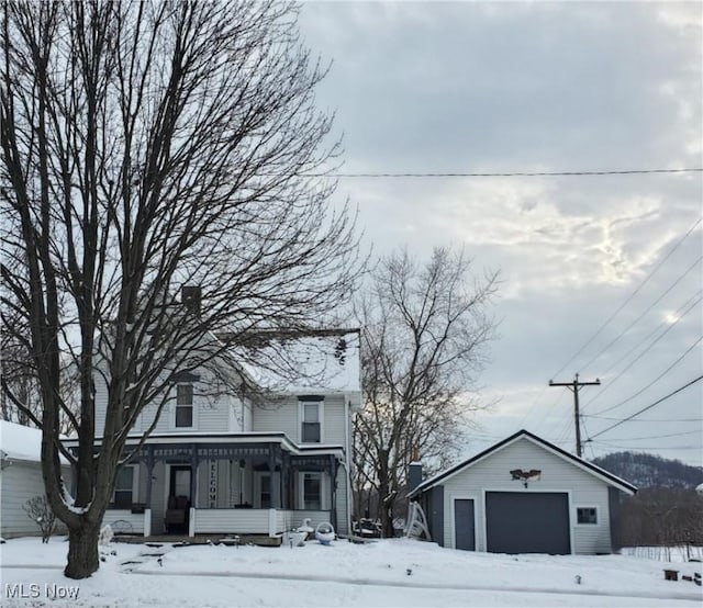 view of front of house with an outbuilding, covered porch, and a garage