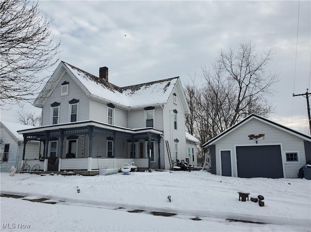 view of snow covered exterior with an outbuilding, covered porch, and a garage