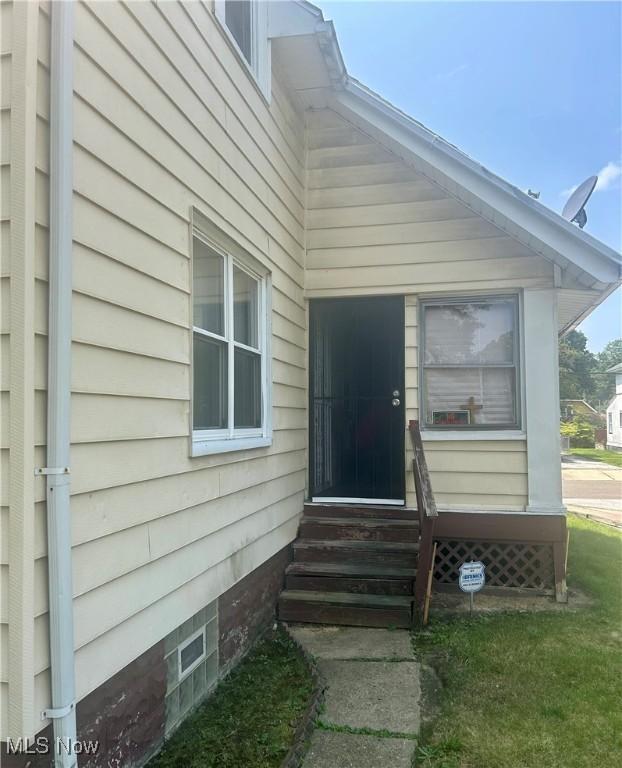 doorway to property featuring a lawn