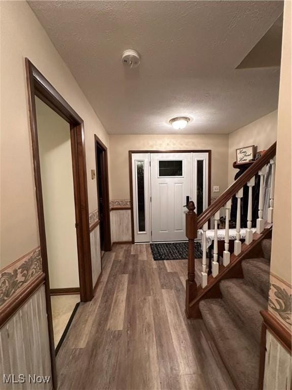 foyer with hardwood / wood-style floors and a textured ceiling