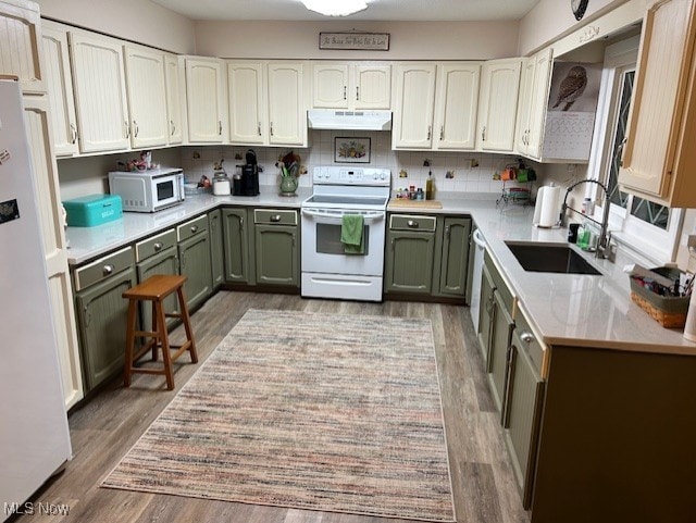 kitchen featuring backsplash, white appliances, sink, white cabinetry, and green cabinets