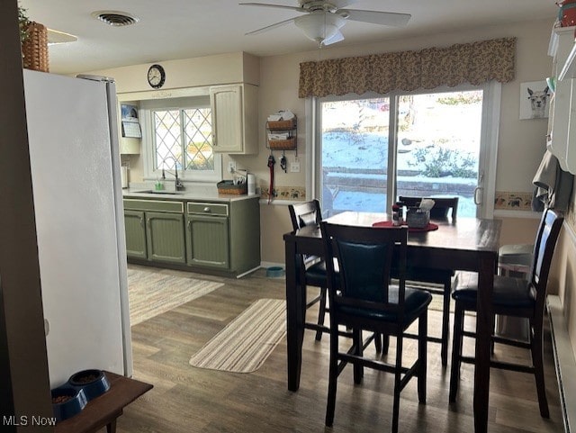 dining space featuring hardwood / wood-style flooring, ceiling fan, and sink