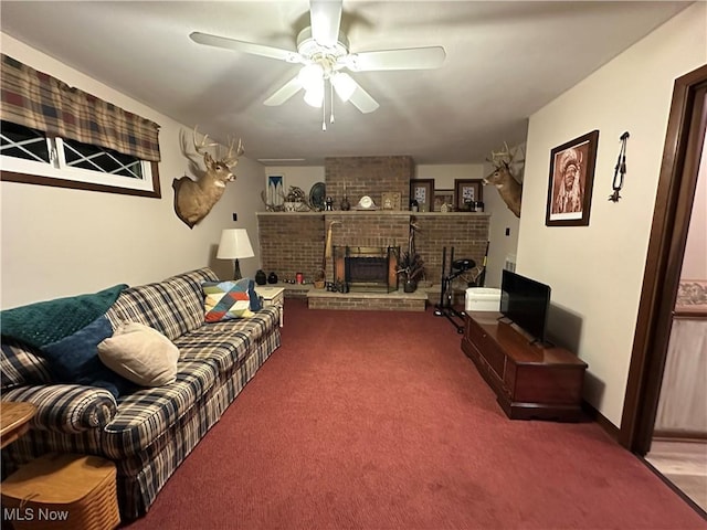 living room with carpet, a brick fireplace, and ceiling fan