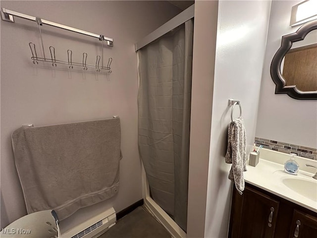 bathroom with vanity, tasteful backsplash, baseboard heating, and walk in shower