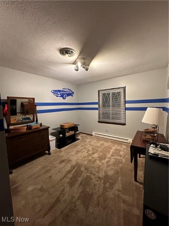 interior space with a textured ceiling, carpet floors, and a baseboard heating unit