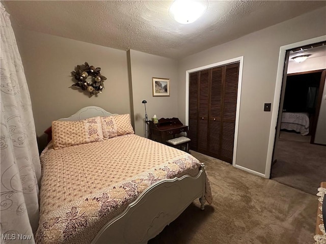 bedroom featuring a textured ceiling, dark carpet, and a closet