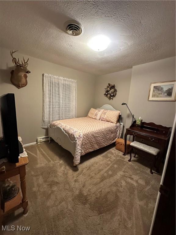 carpeted bedroom with a textured ceiling and baseboard heating