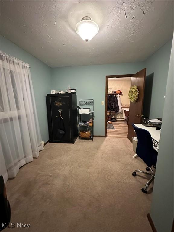 home office with light carpet and a textured ceiling