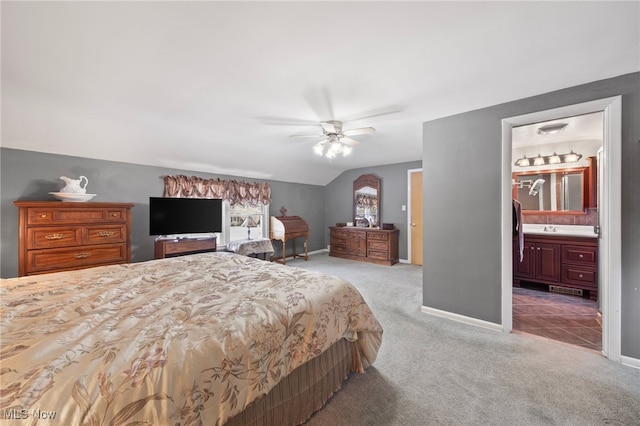 carpeted bedroom featuring ceiling fan, ensuite bathroom, and lofted ceiling