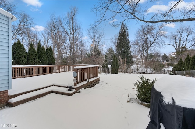 yard covered in snow featuring a wooden deck