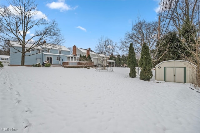 yard layered in snow featuring a storage unit