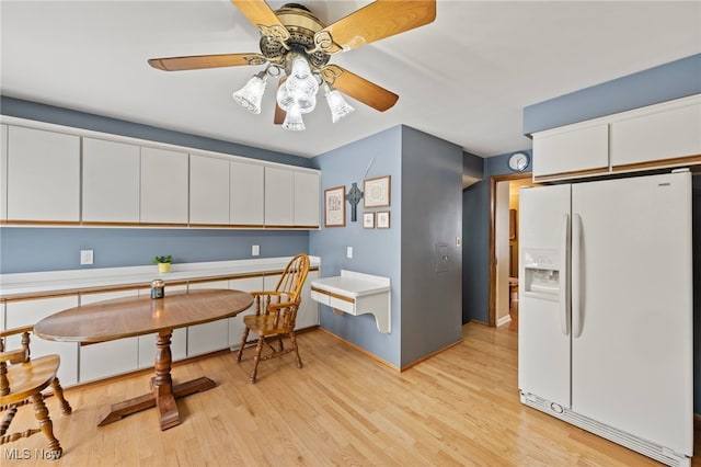 kitchen with ceiling fan, white cabinetry, light wood-type flooring, and white refrigerator with ice dispenser