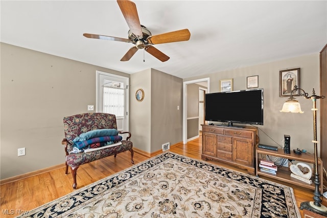 living room featuring light hardwood / wood-style flooring and ceiling fan