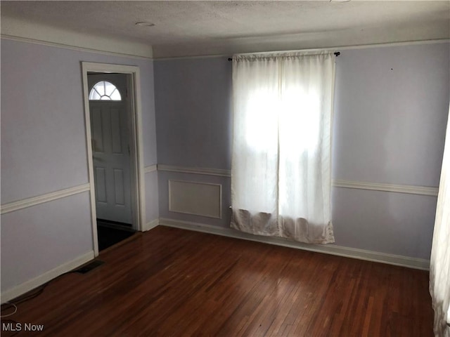 foyer featuring dark hardwood / wood-style flooring and a textured ceiling