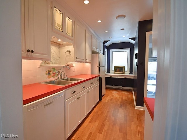 kitchen with stainless steel refrigerator, white cabinetry, sink, and white dishwasher