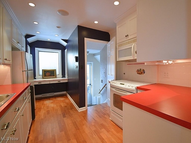 kitchen featuring white cabinetry, backsplash, light hardwood / wood-style floors, lofted ceiling, and white appliances