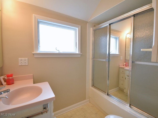 bathroom with vanity, bath / shower combo with glass door, and vaulted ceiling