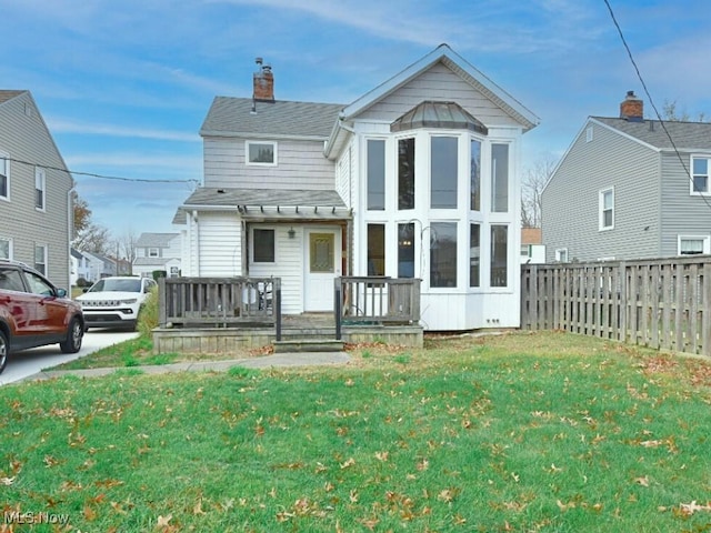 rear view of property with a yard and a wooden deck