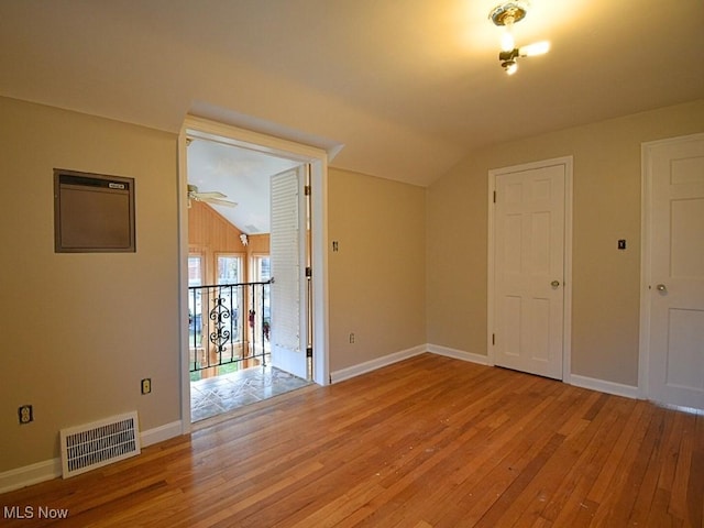 spare room featuring light hardwood / wood-style flooring and lofted ceiling