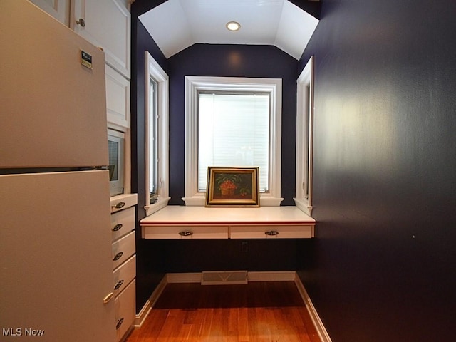 corridor featuring light hardwood / wood-style floors and lofted ceiling