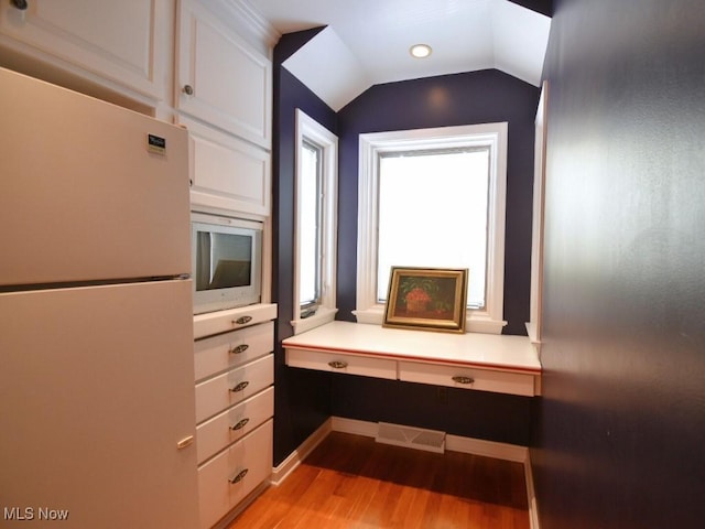 interior space featuring lofted ceiling and light wood-type flooring