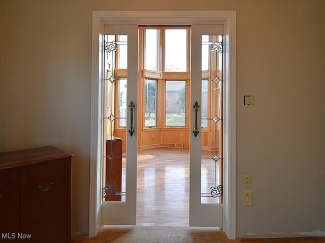 hallway with light wood-type flooring and plenty of natural light