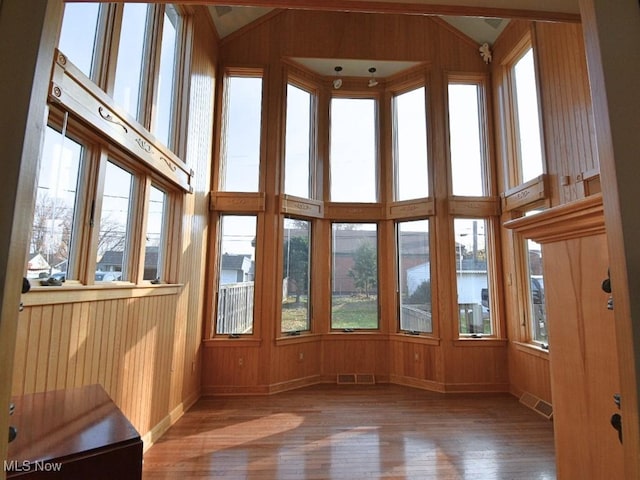 unfurnished sunroom featuring a water view and lofted ceiling