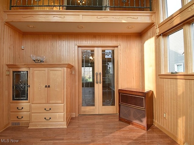 interior space featuring french doors, hardwood / wood-style flooring, and wood walls