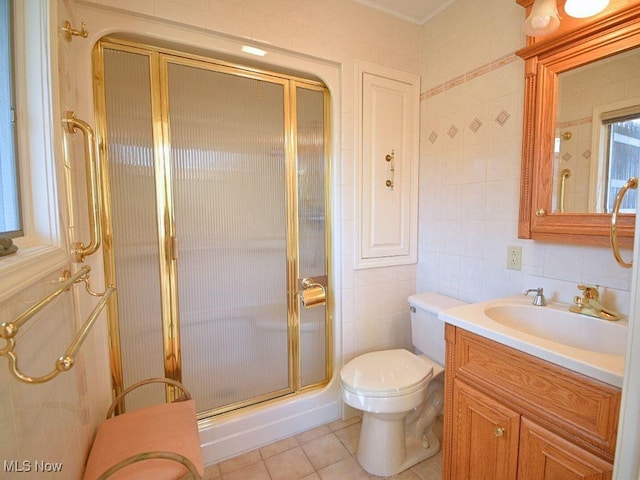 bathroom featuring tile patterned flooring, an enclosed shower, toilet, vanity, and tile walls