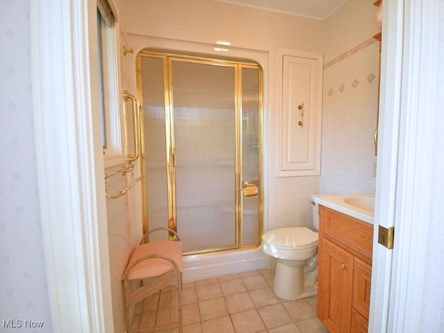 bathroom featuring tile patterned floors, vanity, toilet, and an enclosed shower