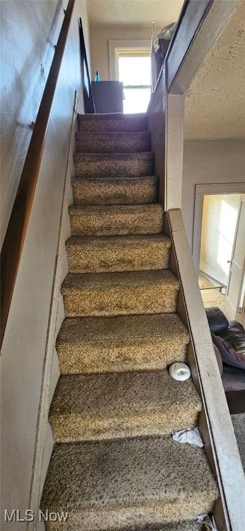 stairs with a textured ceiling