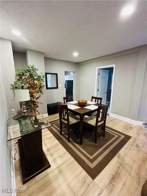 dining area featuring hardwood / wood-style floors and a textured ceiling