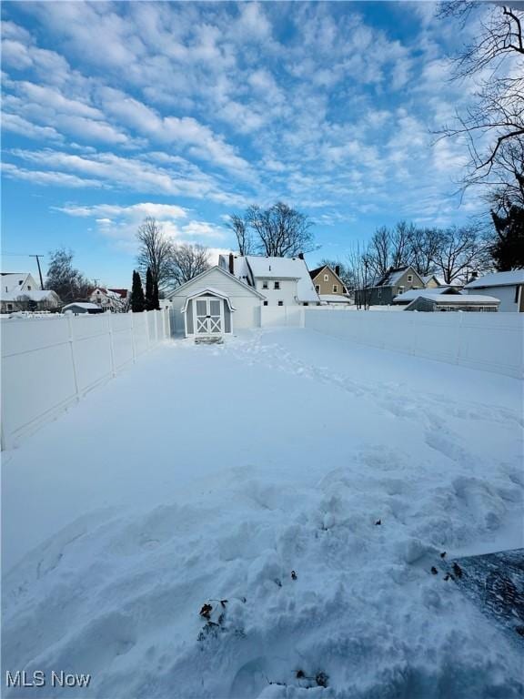 snowy yard featuring an outdoor structure