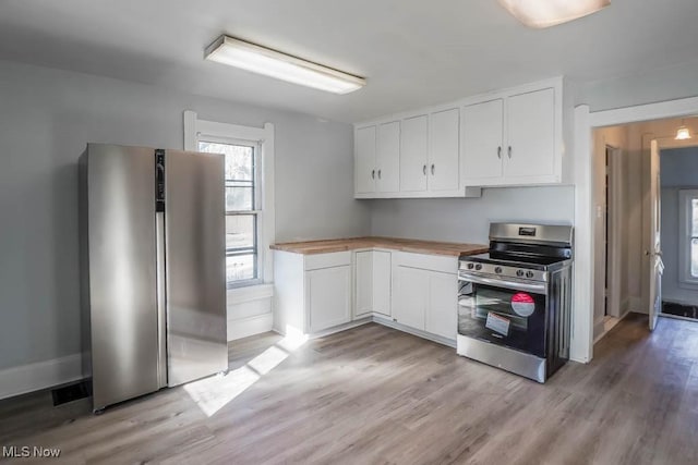 kitchen featuring wood counters, light wood-type flooring, white cabinetry, and appliances with stainless steel finishes