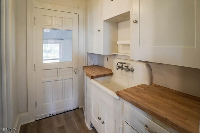 kitchen featuring wooden counters, white cabinets, dark hardwood / wood-style floors, and sink