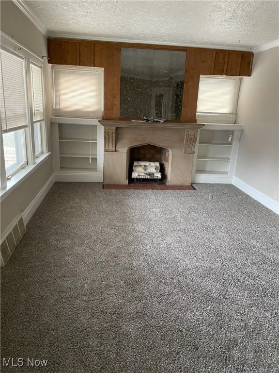 unfurnished living room featuring carpet flooring, a textured ceiling, and ornamental molding