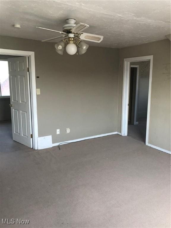 spare room featuring carpet flooring, ceiling fan, and a textured ceiling