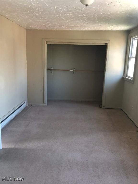 unfurnished bedroom featuring a closet, a baseboard radiator, and a textured ceiling
