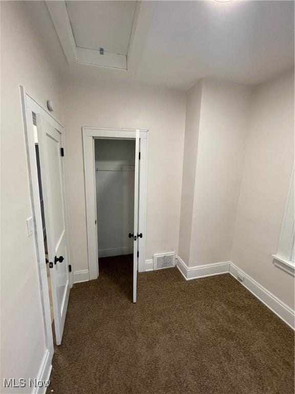 empty room featuring dark carpet