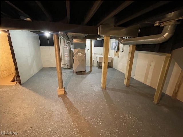 basement featuring heating unit, water heater, and sink