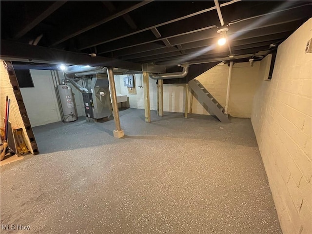 basement with heating unit, electric panel, and gas water heater