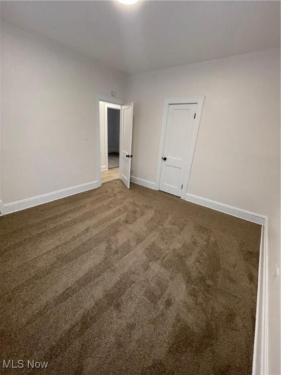 unfurnished room with dark colored carpet