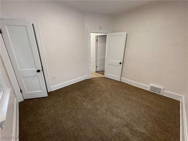 unfurnished bedroom with dark carpet