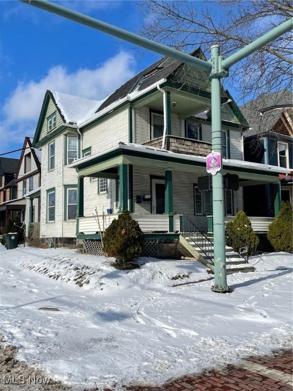 view of snowy exterior with covered porch